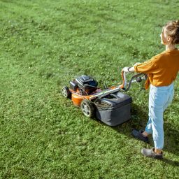a woman mows her lawn