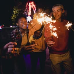 Group of friends lighting sparklers on the fourth of July