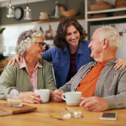 Senior father and old mother sharing tea and heartfelt conversation with daughter at home at tea time.