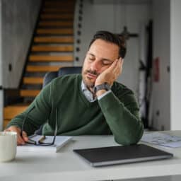 Tired man propping his head up with his hand.