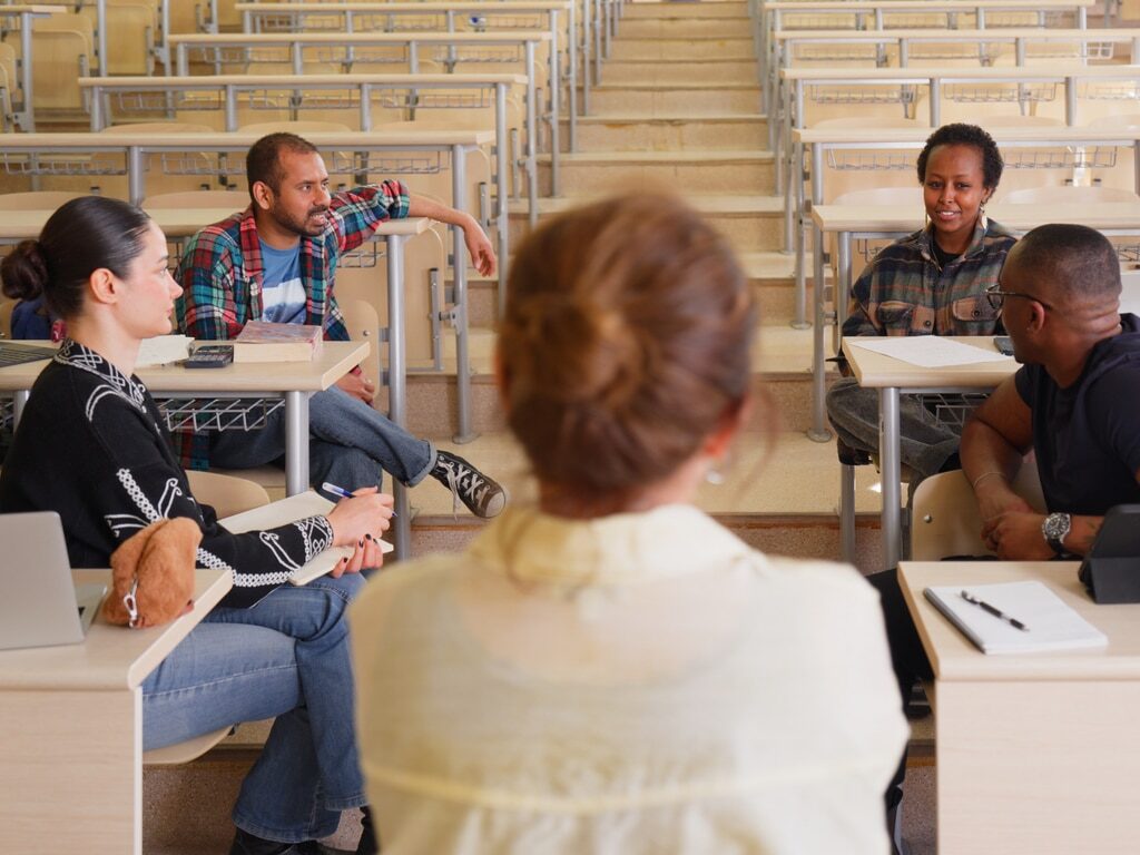 Group of college students sitting in a classroom having a discussion.